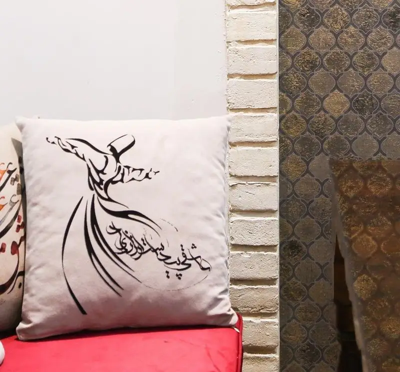 دکوراسیون داخلی رستوران سنتی خوان کرم: پشتی با طرح درویش سماع‌کننده و خوشنویسی فارسی، نمادی از فرهنگ اصیل ایرانی.