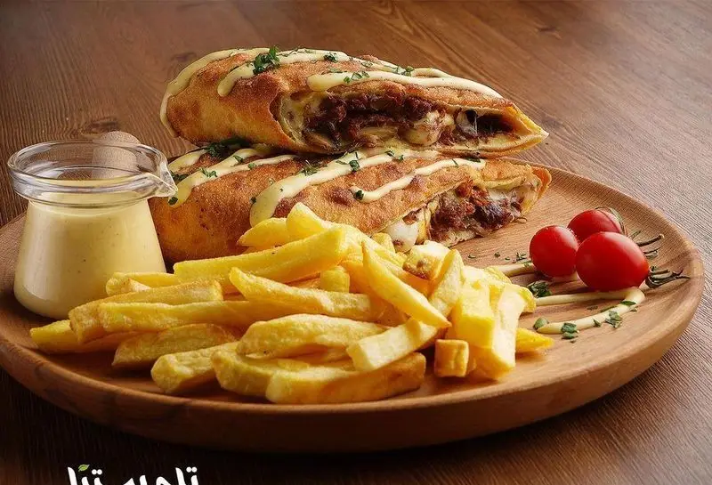 رول پیتزای گوشت و پنیر آب شده فست فود تله پیتزا همراه با سیب زمینی سرخ کرده و سس مایونز خوشمزه.