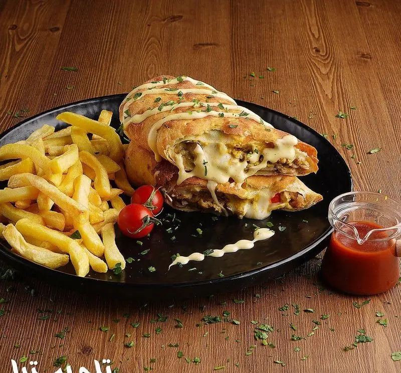 کالزون پنیری لذیذ و پرملات به همراه سیب زمینی سرخ کرده طلایی و سس کچاپ، پیشنهادی جذاب از فست فود تله پیتزا. تجربه‌ای خاص.