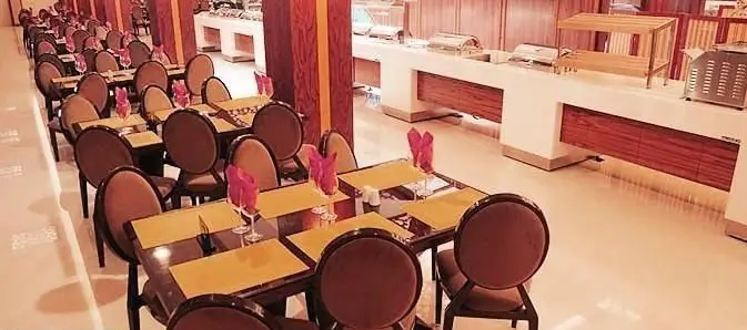 فضای داخلی وسیع و دلنشین رستوران شاین با میز و صندلی‌های مدرن و شیک آماده پذیرایی و بوفه کامل غذا در پس‌زمینه.