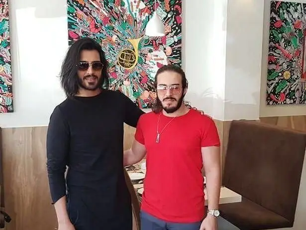 تصویری از دو مشتری در رستوران ایتالیایی رو ب رو با دیوارنگاره‌های هنری و فضای گرم و صمیمی. محیطی عالی برای تجربه غذا.