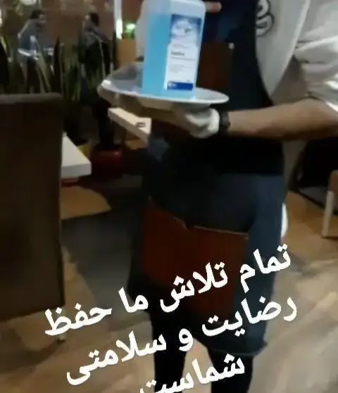 کارکنان رستوران ایتالیایی رو ب رو، ضدعفونی کننده دست را روی سینی برای مشتریان سرو می‌کنند، نشانه‌ای از اهمیت به سلامت و رضایت.
