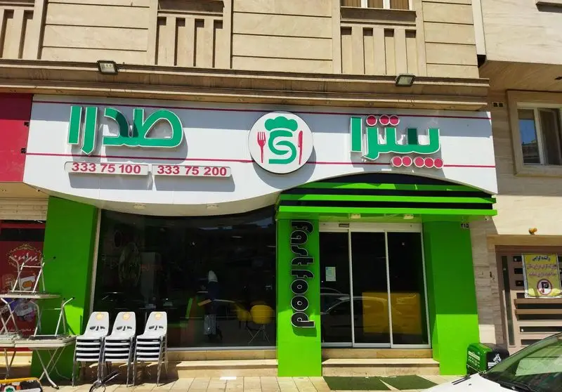 نمای فست فود صدرا با تابلوی سبز و سفید، لوگوی Chef’s Hat و S، شماره‌های تماس 333 75 100 و 333 75 200 و ورودی با نوشته FastFood.
