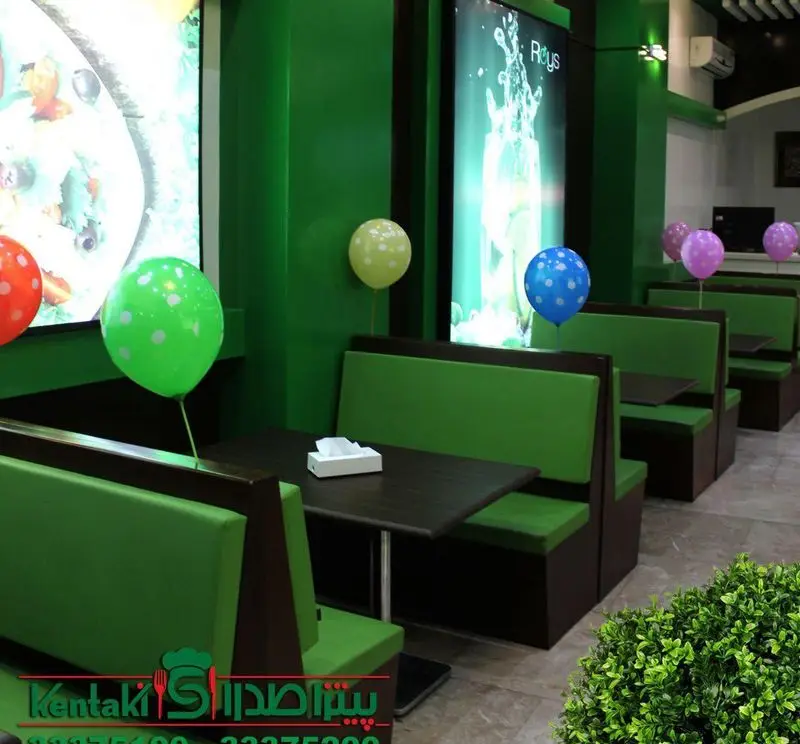 دکوراسیون داخلی مدرن و جذاب فست فود صدرا با میز و صندلی‌های سبز راحت و بادکنک‌های رنگی، محیطی دلنشین برای مشتریان
