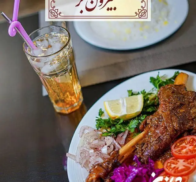 تصویری جذاب از ماهيچه گوسفندی با برنج زعفرانی، لیمو و سبزیجات تازه در رستوران شاندیز. لذت یک وعده غذای اصیل.