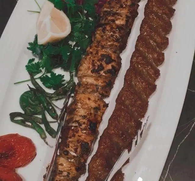 تجربه کباب اصیل ایرانی در رستوران شاندیز: بشقاب کباب کوبیده و جوجه کباب همراه با لیمو، سبزیجات تازه و فلفل کبابی.