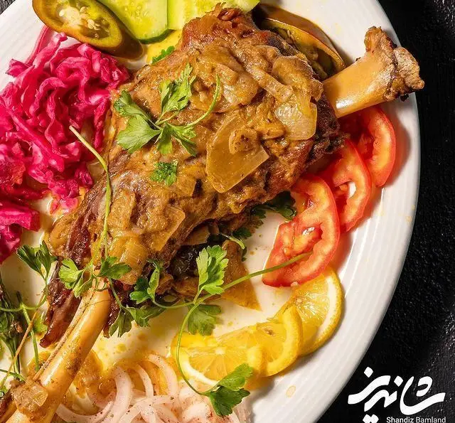 ماهیچه گوسفندی آبدار و خوشمزه رستوران شاندیز باملند، سرو شده با مخلفات رنگارنگ، تجربه‌ای بی‌نظیر از غذای اصیل ایرانی.