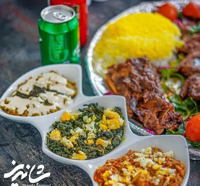 تصویر غذای لذیذ رستوران شاندیز شامل کباب، پلو زعفرانی و خورشت، تجربه‌ای به یادماندنی از غذای سنتی ایرانی با کیفیت.
