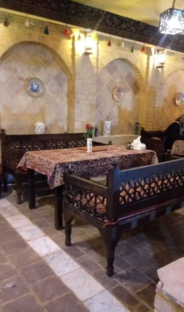 نمای داخلی رستوران سنتی نون و نمک فخر الملوک با دکوراسیون ایرانی، تخت‌های چوبی و دیوارهای طاق‌دار آجری، فضایی دلنشین.