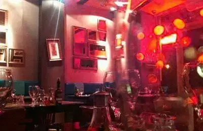 فضای داخلی شیک و مدرن رستوران فرنگی ژینر با نورپردازی خاص و میزهای چیده شده برای شب‌نشینی و صرف نوشیدنی و غذا.