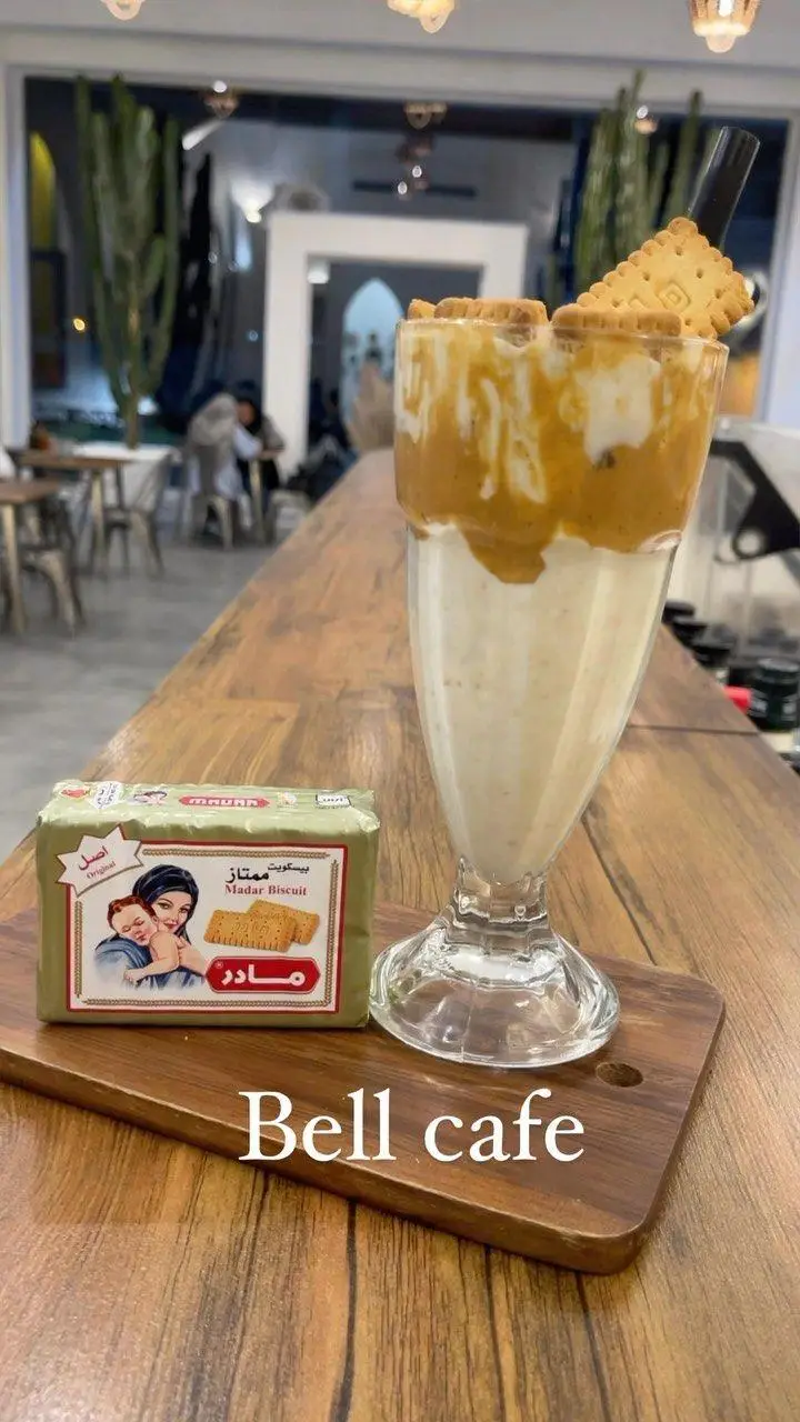 تصویری از یک نوشیدنی لذیذ و محبوب در بل کافه که با بیسکویت مادر سرو شده است. تجربه‌ای بی‌نظیر از طعم و محیط دلنشین کافه.