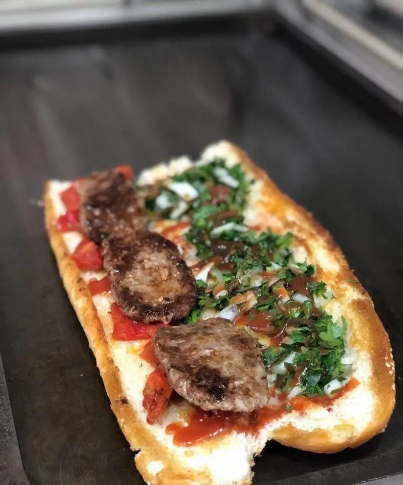 ساندویچ کوفته مخصوص ساندویچی کمال خان با گوشت تازه و کباب‌شده، گوجه‌فرنگی و سبزیجات معطر، تجربه‌ای لذیذ از فست‌فود ایرانی.