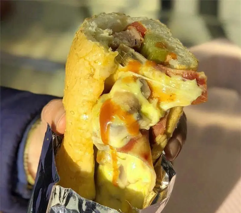 ساندویچ ویژه ساندویچی کمال خان با پنیر آب شده، قارچ و سس، یک انتخاب خوشمزه فست فود برای تجربه غذایی دلپذیر.