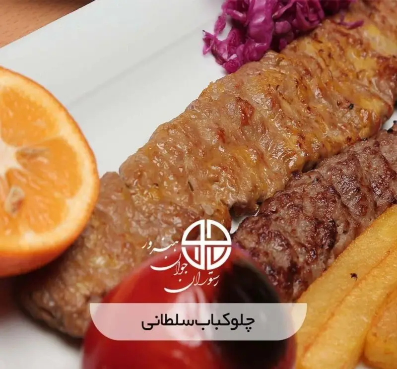 عکس چلوکباب سلطانی خوشمزه و باکیفیت رستوران جوان هنرور ۲ شامل کباب برگ و کوبیده با تزیین پرتقال، سیب زمینی و کلم قرمز.