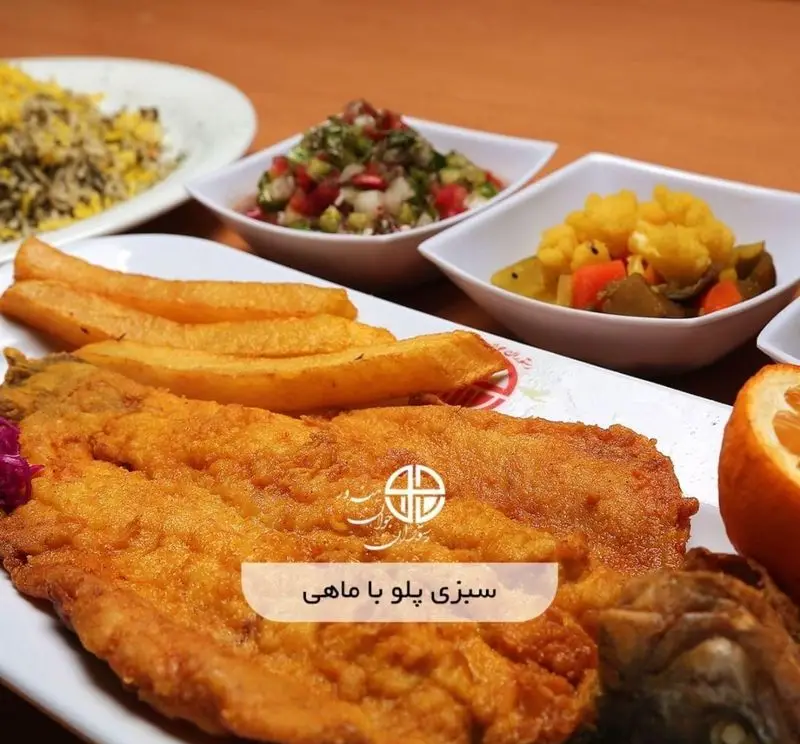 یک بشقاب کامل سبزی پلو با ماهی سرخ شده طلایی به همراه سیب زمینی سرخ کرده، سالاد شیرازی و ترشی در رستوران جوان هنرور ۲.