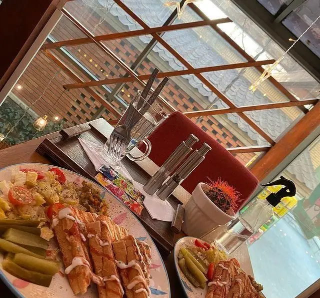 فضای دنج و دلنشین کافه مونو با سرو انواع غذا و ساندویچ‌های خوشمزه، صبحانه‌های لذیذ و دکوراسیون زیبای داخلی در محیطی روشن و مدرن.