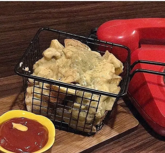 سیب زمینی سرخ کرده کافه مونو با سس پنیر مخصوص، سرو شده در سبد فانتزی. بهترین پیش غذای خوشمزه و متفاوت.