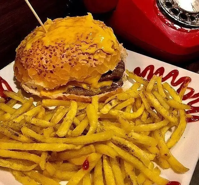 همبرگر دوبل پنیر لذیذ و پرطرفدار کافه مونو با سیب زمینی سرخ کرده طلایی و سس کچاپ، یک انتخاب عالی برای فست فود.