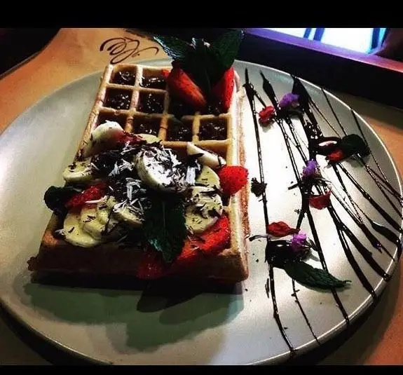 عکس دسر وافل کافه مونو با ترکیب موز، توت فرنگی، شکلات و برگ نعناع تازه، انتخابی عالی برای دوستداران طعم‌های شیرین و تازه