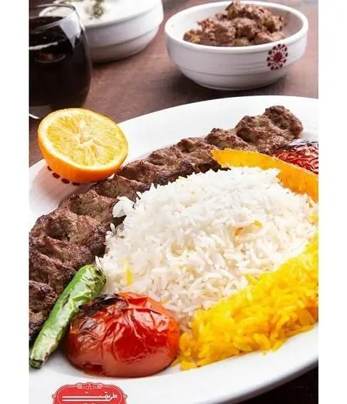 چلوکباب کوبیده لذیذ رستوران طریقت شعبه غرب با برنج زعفرانی، گوجه، فلفل کبابی، پرتقال، ماست و خیار و نوشابه
