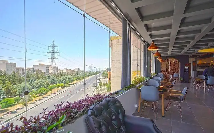 رستوران رزاموند با دکوراسیون داخلی مدرن، سقف کاذب زیبا، مبلمان شیک و چشم‌انداز دلنشین به شهر و فضای سبز خیابان.