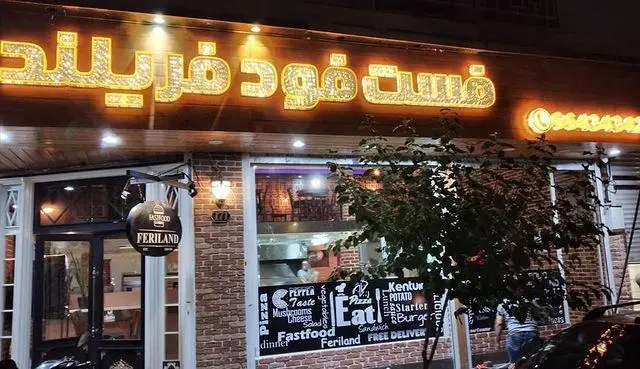 نمای جذاب فست فود فارسیز در شب، با تابلوی نئون روشن و طراحی مدرن. ارائه دهنده انواع پیتزا، برگر و ساندویچ با ارسال رایگان.