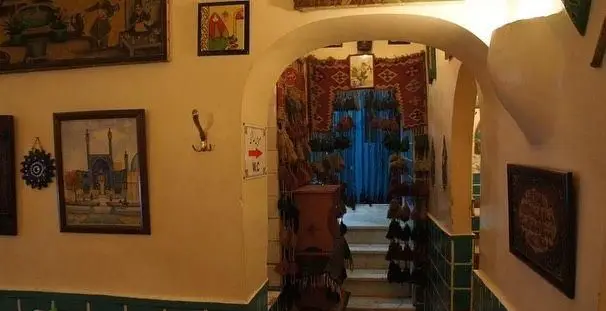 فضای داخلی دلنشین و سنتی رستوران دیزی سرا با نقاشی‌های دیواری، راهروی طاق‌دار به سمت پله‌ها و دکوراسیون گرم ایرانی.