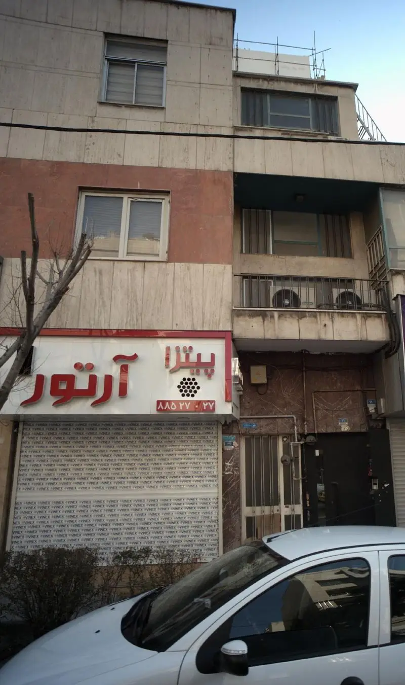 نمای بیرونی رستوران پیتزا آرتور، یک فست فود محبوب در تهران، با تابلوی روشن و واضح آن در یک ساختمان شهری.