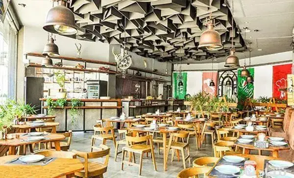 فضای داخلی دنج و زیبای رستوران ایتالیایی اسپرلوس با میز و صندلی چوبی، طراحی خاص سقف و نورپردازی دلنشین.