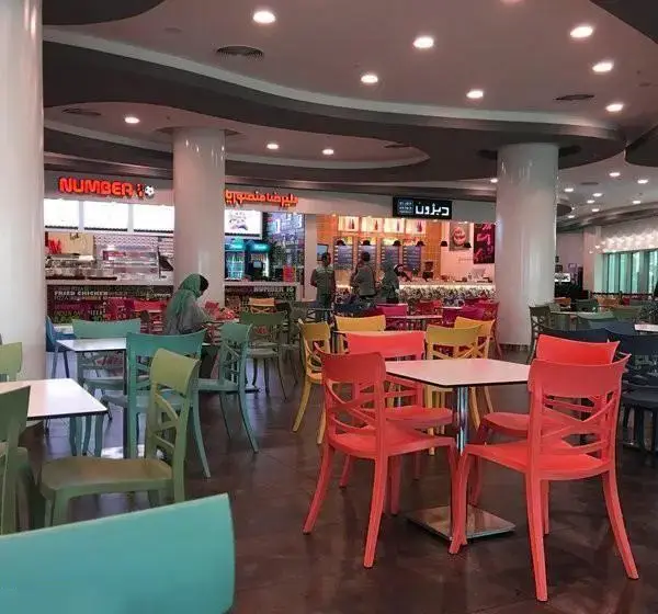 فودکورت پرجنب‌وجوش مجتمع تجاری ارگ با میز و صندلی‌های رنگارنگ، مشتریان و رستوران‌های متنوعی چون نامبر ۸ و دیزون.