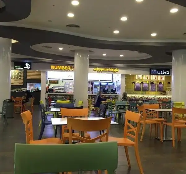 فضای فودکورت مدرن و دلنشین مجتمع تجاری ارگ تهران، با تنوع رستوران‌ها و میز و صندلی‌های رنگی برای مشتریان.