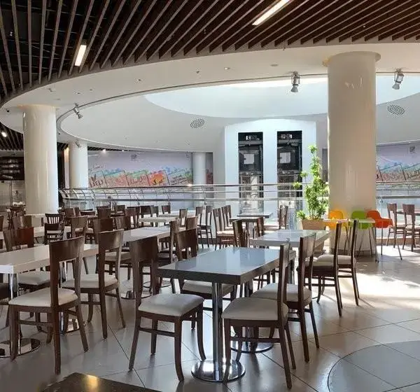 فضای فودکورت بزرگ و مدرن مجتمع تجاری ارگ با میز و صندلی‌های چوبی شیک، محیطی دلنشین برای صرف غذا در تهران.