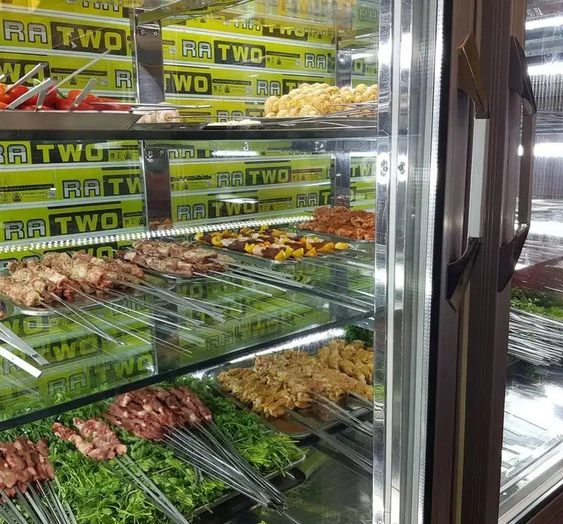 نمایش انواع کباب‌های تازه جگر، جوجه و گوشت بر روی سیخ و سبزیجات معطر در جگرسرای لیموترش، آماده برای مشتریان.