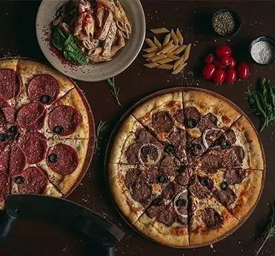 انواع پیتزاهای لذیذ شامل پپرونی و گوشت، به همراه پاستا پنه کرمی در رستوران و کافی شاپ دورهمی برای یک تجربه غذایی فراموش نشدنی.