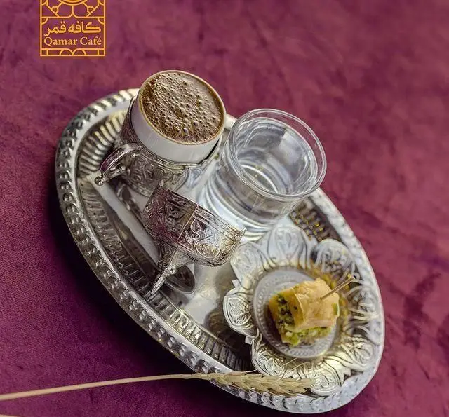 پذیرایی لوکس قهوه ترک و باقلوای پسته در سینی نقره، همراه با آب، نمادی از اصالت در رستوران و کافی شاپ دورهمی.