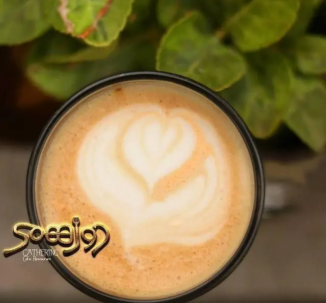 یک فنجان لاته داغ با لاته آرت قلبی زیبا در کافی شاپ و رستوران دورهمی، بهترین مکان برای جمع شدن با دوستان.