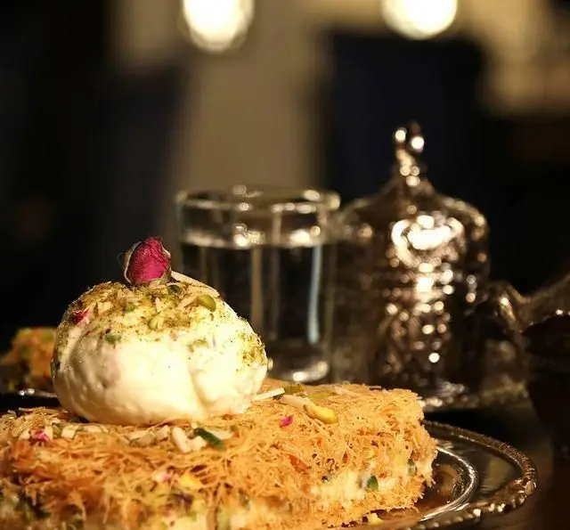 دسر کنافه سنتی با بستنی وانیلی، پسته و غنچه رز، انتخابی دلپذیر در رستوران و کافی شاپ دورهمی برای تجربه طعمی خاص.