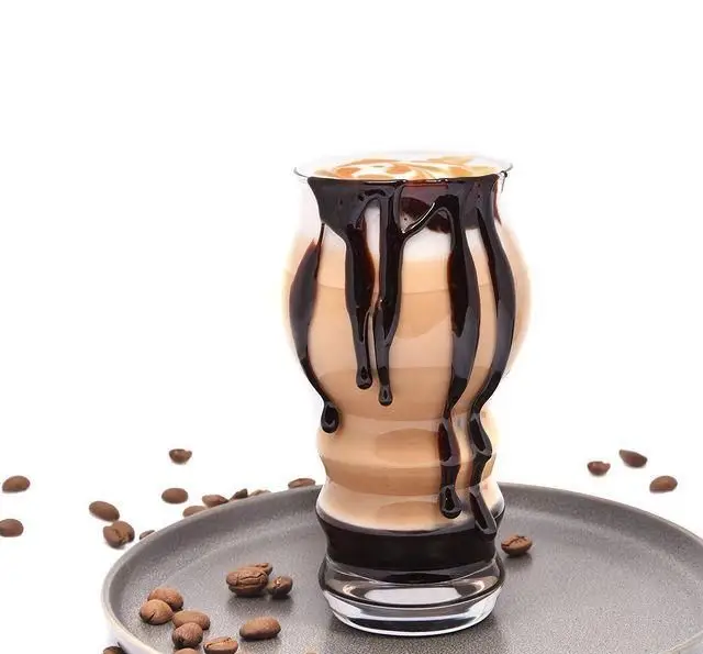 نوشیدنی قهوه موکا یا لاته خوشمزه با سس شکلات و کارامل در لیوان شیک، آماده سرو در رستوران و کافی شاپ دورهمی.