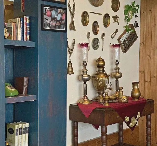 دکوراسیون سنتی و دلنشین رستوران و کافی شاپ دورهمی، با قفسه کتاب، تلفن قدیمی، سماور و اشیاء عتیقه.