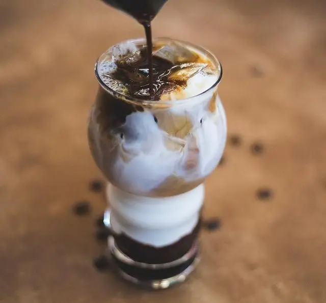قهوه آیس اسپرسو لاته تازه و خنک رستوران و کافی شاپ دورهمی، در حال آماده سازی برای سرو. نوشیدنی لذیذ.