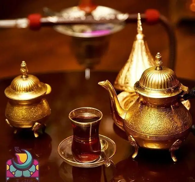 تجربه دلنشین دورهمی در رستوران و کافی شاپ با سرویس چای سنتی طلایی، فنجان چای تازه دم و قلیان عربی آماده برای میزبانی.