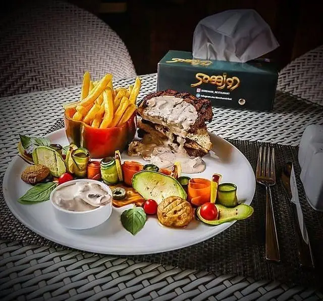 تجربه طعم لذیذ در رستوران دورهمی: بشقاب استیک/مرغ با سس قارچ، سیب زمینی سرخ کرده و سبزیجات گریل‌شده، سرو شیک و مجلسی.