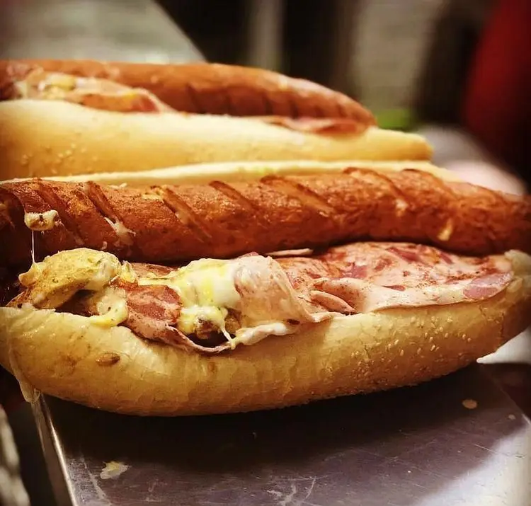 ساندویچ اژدر زاپاتا، یک ساندویچ بزرگ و پرملات شامل سوسیس سرخ شده، ژامبون و پنیر ذوب شده از فست فود اژدر زاپاتا.