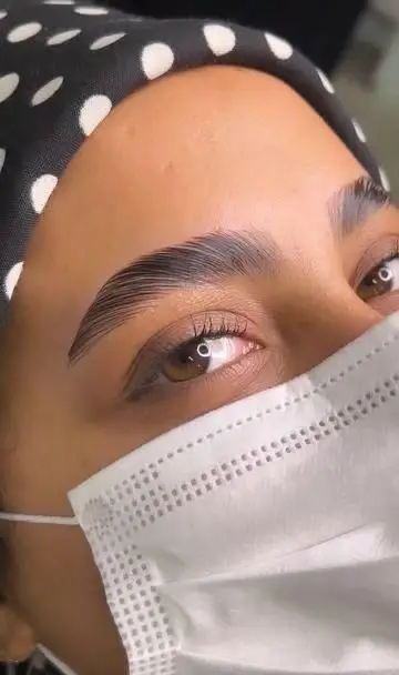 تصویر نزدیک از مراحل لیفت و لمینت ابروهای طبیعی و پرپشت دخترانه در سالن زیبایی تخصصی با استفاده از بهترین مواد تقویت‌کننده