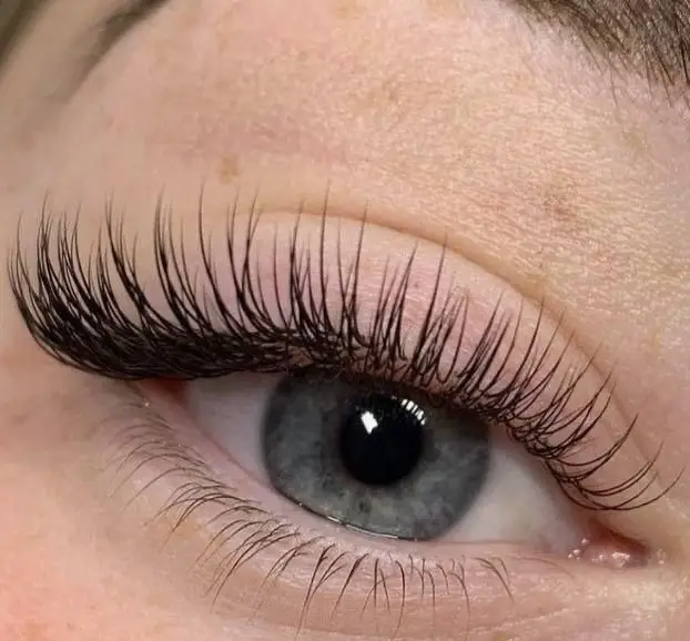 نمونه کار حرفه‌ای کاشت و اکستنشن مژه والیوم مشکی، بلند و پرپشت روی چشم با عنبیه طوسی رنگ در سالن زیبایی پانیذ خانی