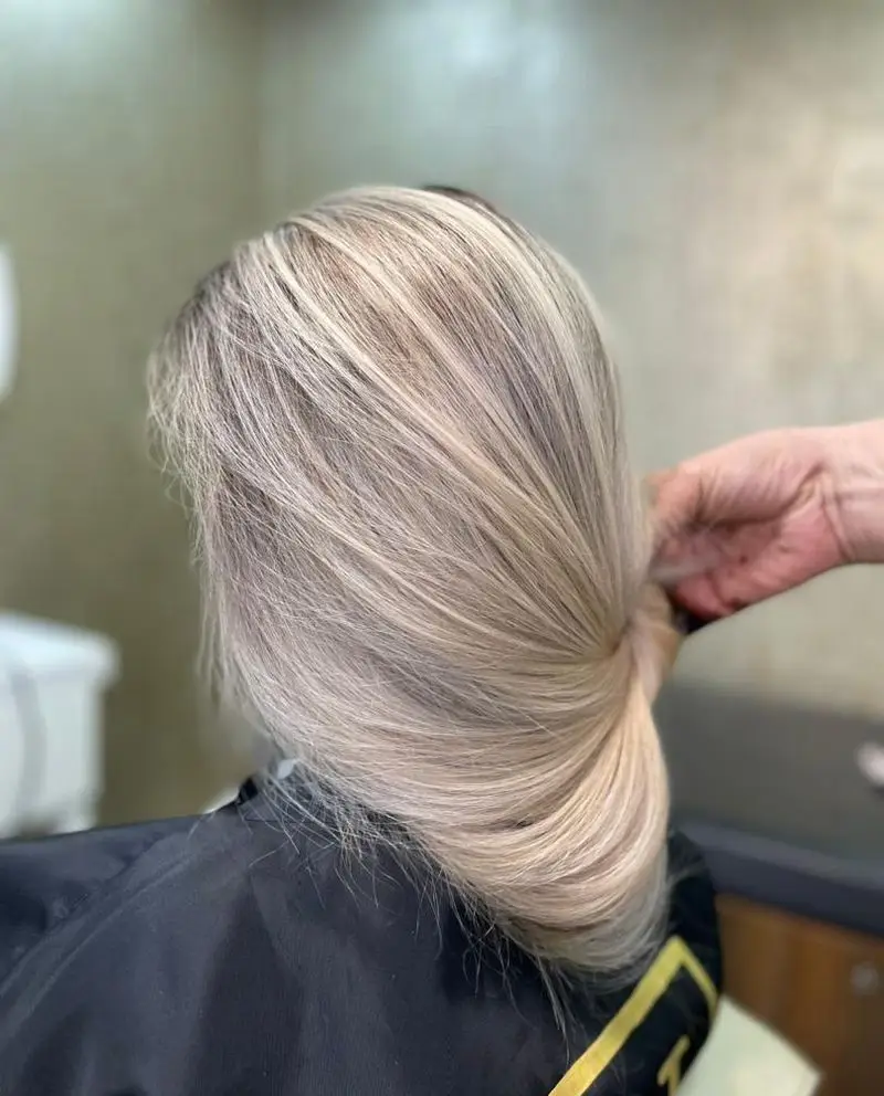 نمای پشت سر از رنگ و دکلره موی بلوند استخوانی و شینیون ساده و مرتب شده در بخش خدمات موی سالن زیبایی پانیذ خانی