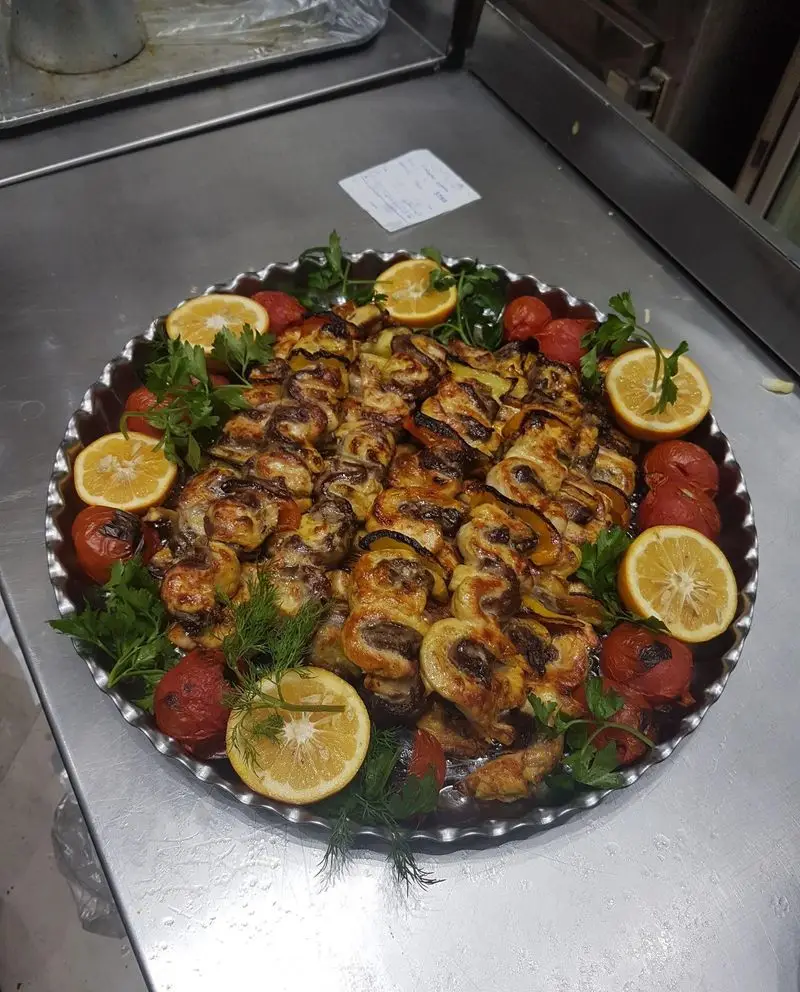 سینی بزرگ کباب مرغ و سبزیجات تازه، تزئین شده با لیمو و سبزیجات معطر در رستوران ایرانی و فست فود بریکا. غذای لذیذ