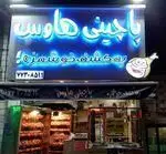 تابلوی جذاب نئون کسب و کار "پاچینی هاوس مرغ کنتاکی" با لوگوی ران مرغ، شماره تلفن و نمایش دیدنی مرغ‌های سوخاری و بریان آماده در این فست فود.