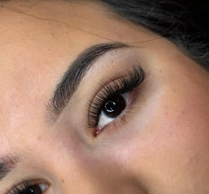 تصویری از اکستنشن مژه والیوم و فرم دهی ابرو در سالن زیبایی و آرایشگاه زنانه هرمیسا برای نگاهی گیرا و جذاب.