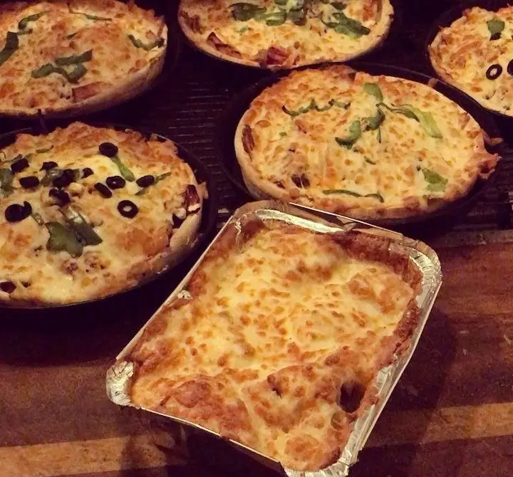 تصویری از پیتزاهای داغ و لازانیای پر پنیر فست فود سه فر، با تاپینگ‌های متنوع، غذایی خوشمزه و تازه برای مشتریان عزیز.